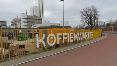 912421 Afbeelding van de tekst 'KOFFIEKWARTIER' op het hek langs het fabrieksterrein van Jacobs Douwe Egberts ...